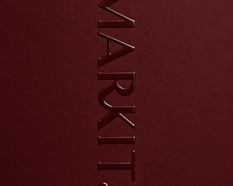 The MARKIT wordmark embossed into burgundy cardstock